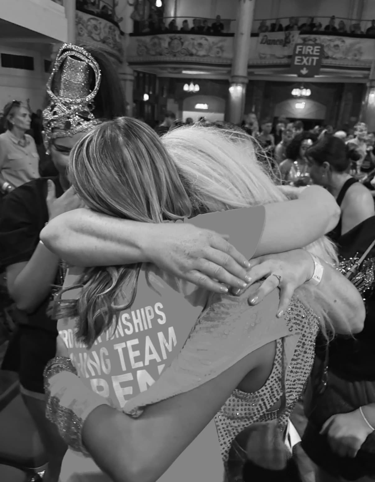 Coaches and dancers hugging at competition